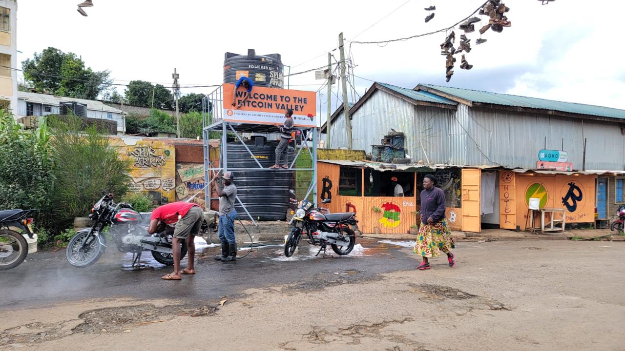 Workers washing motorcycles outdoors in Kenya, an example of vehicle-washing work.
